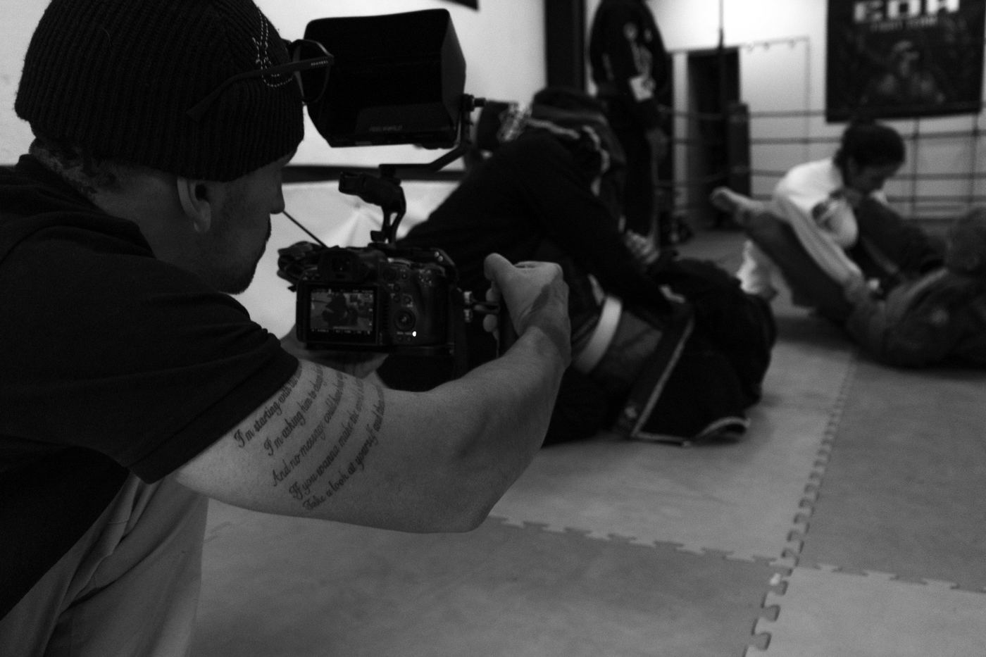 Camarógrafo grabando desde el piso durante un entrenamiento, blanco y negro